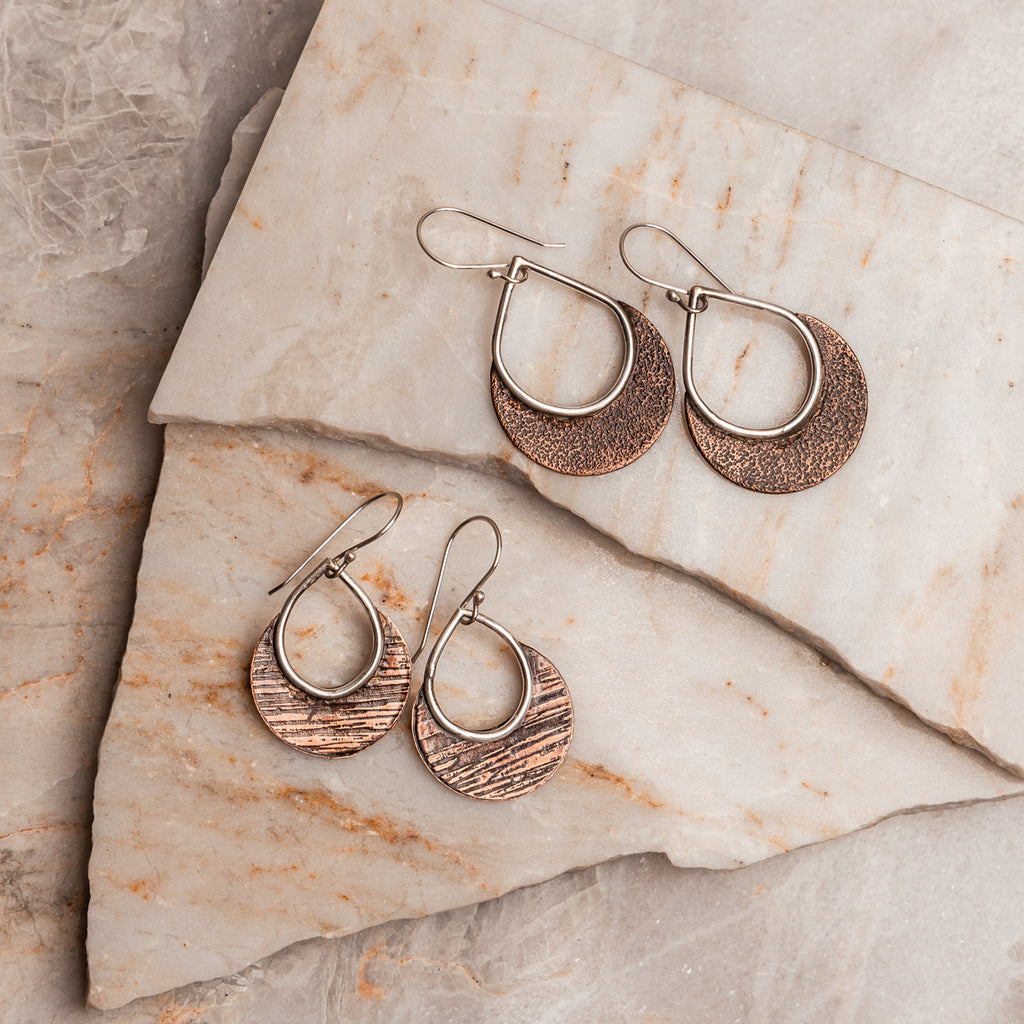 "Bohemian Delphine Earrings showcasing contrasting copper and sterling silver with distinctive hammered texture."

