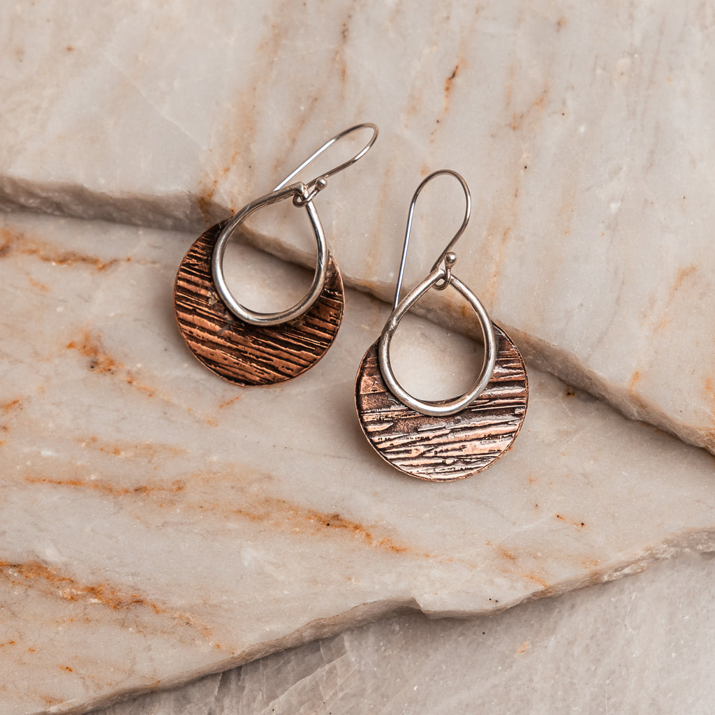 "Bohemian Delphine Earrings showcasing contrasting copper and sterling silver with distinctive hammered texture."

