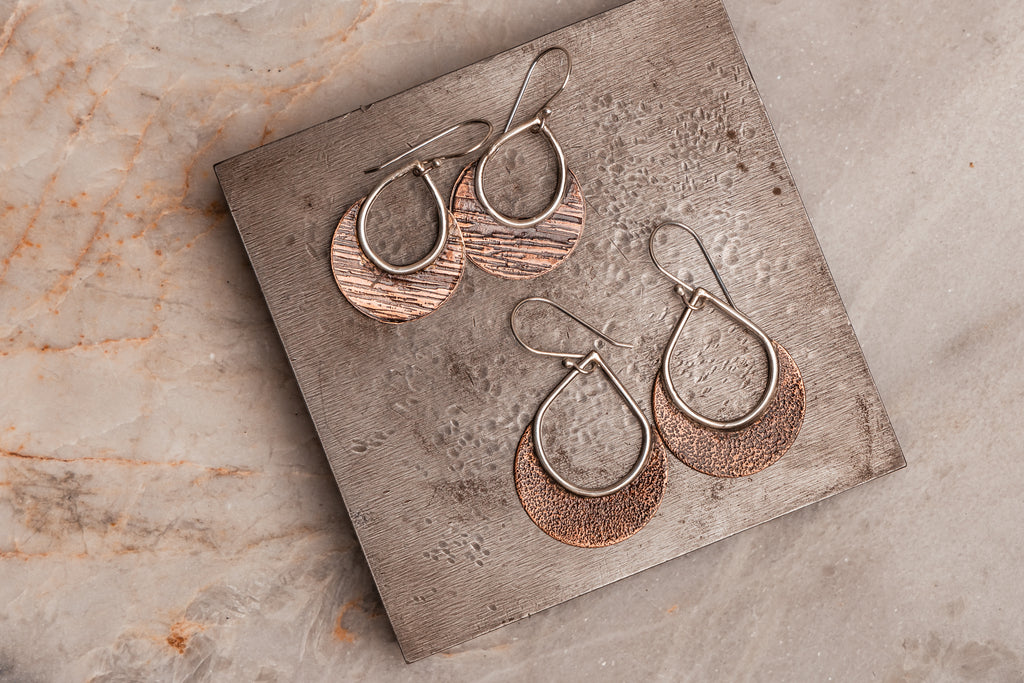 "Bohemian Delphine Earrings showcasing contrasting copper and sterling silver with distinctive hammered texture."

