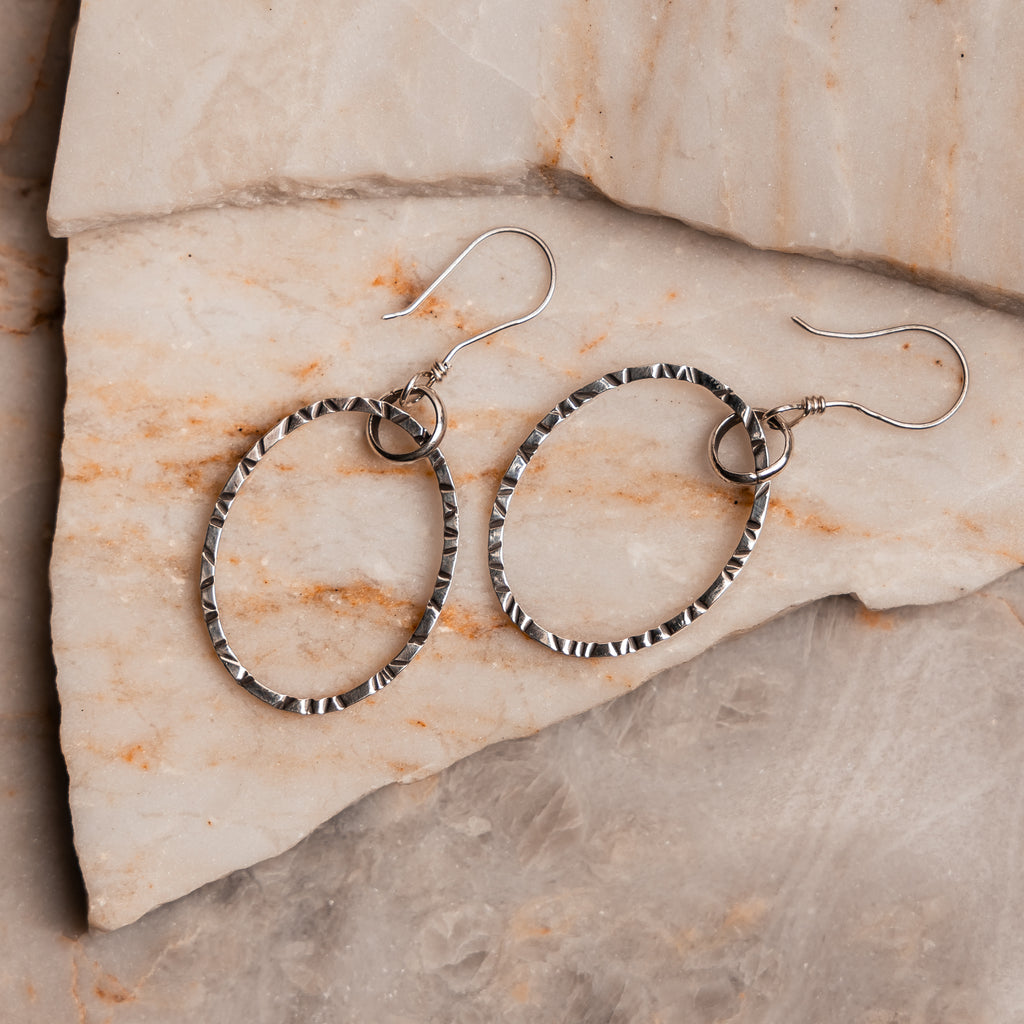 Artisan-made oval hoop earrings featuring intricate hand-hammered details