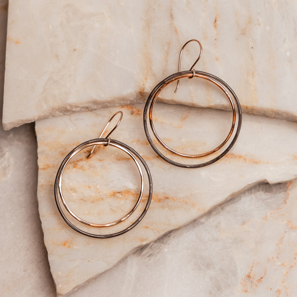 "Helena Earrings featuring mixed metal hoops with shiny gold-filled and oxidized sterling silver design."

