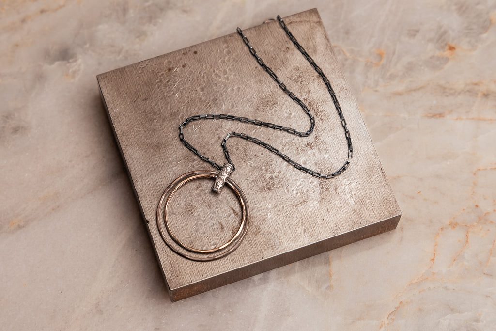 "Closeup of the Helena Necklace featuring a shiny gold-filled pendant contrasted with oxidized sterling silver chain."

