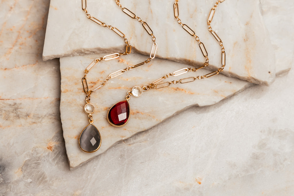 “Leighton Necklace: Adjustable Gold Chain and Gemstone Pendant”: Elevate your look with this handcrafted necklace—choose garnet or Mona Lisa Stone. Ideal for gifting or personal wear. 🌟✨