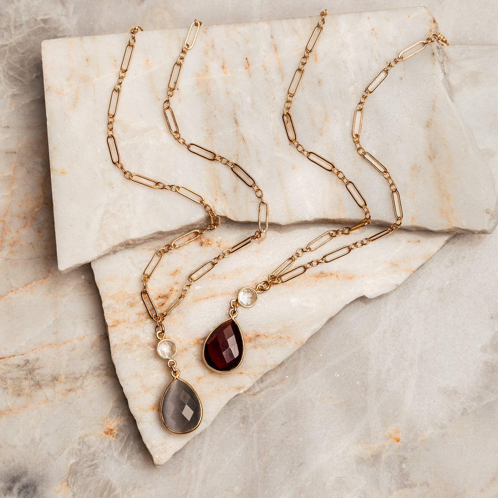 “Handcrafted Leighton Necklace with Garnet Pendant”: A sophisticated gold overlay chain necklace featuring a faceted garnet pendant, bezeled in gold vermeil. Adjustable length, perfect for gifting.