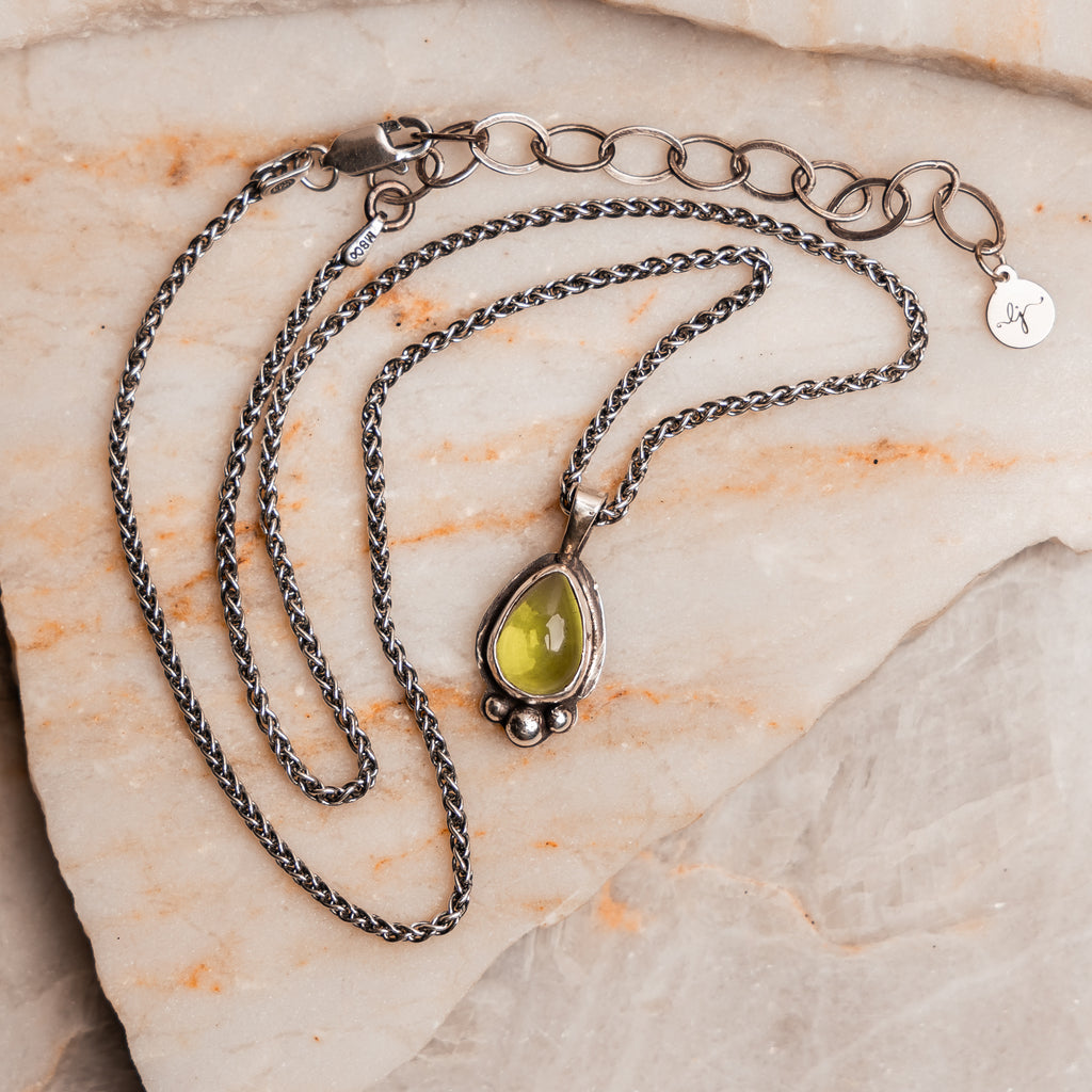 Nature-inspired Lily Necklace with green peridot and hand-forged silver details