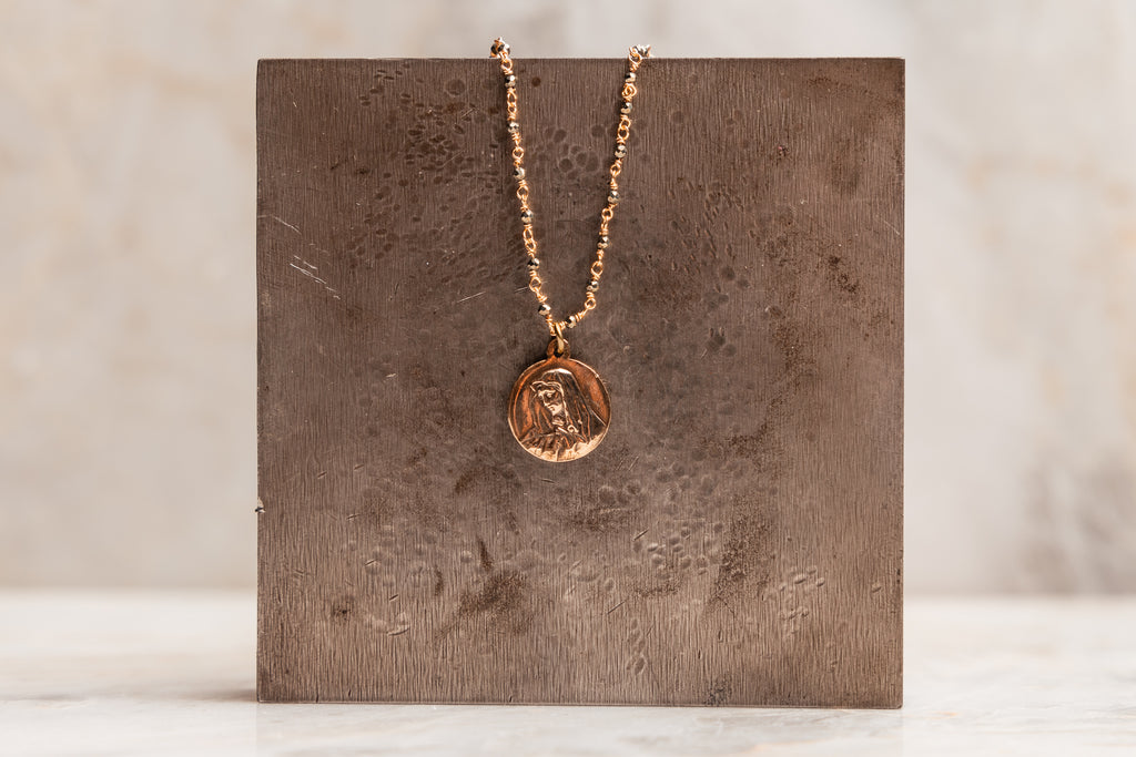 "Vintage-inspired Catholic necklace with pyrite chain and bronze Marian medallion."

