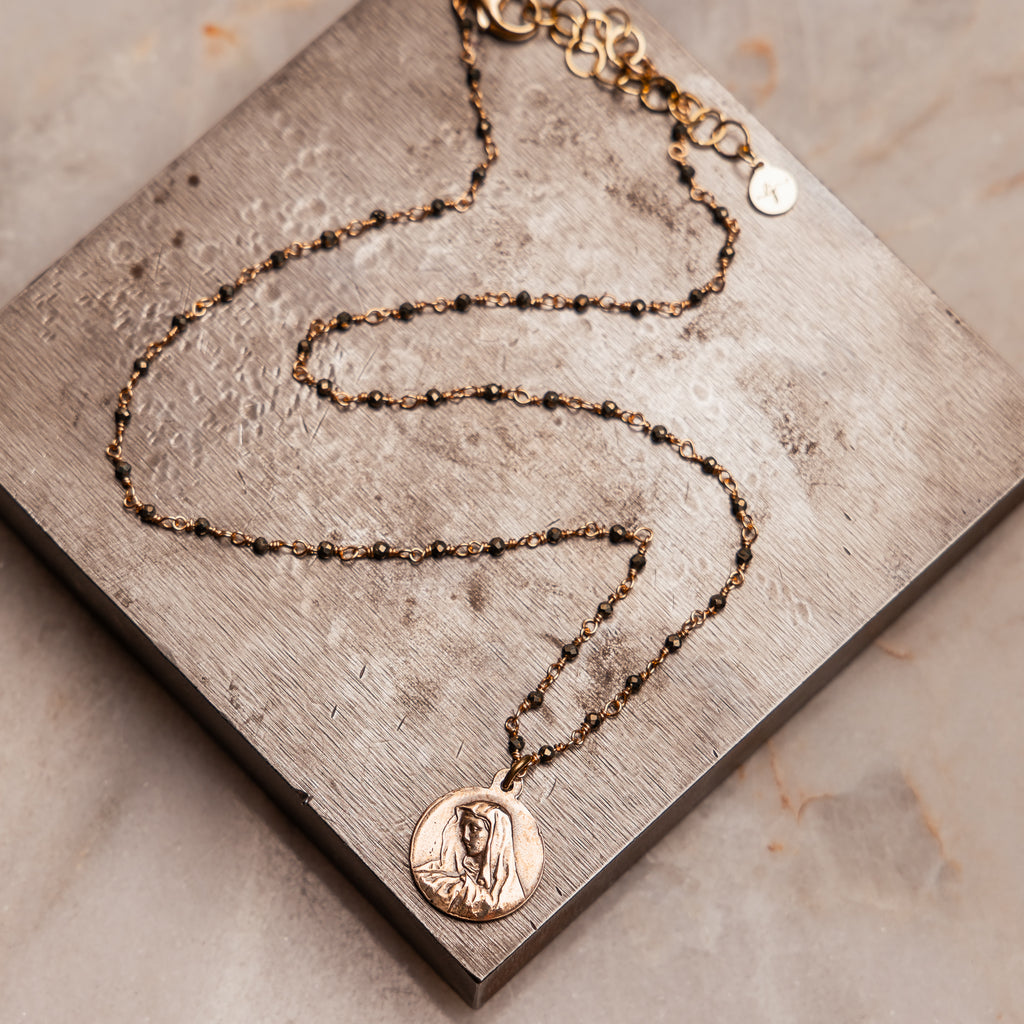 "Miriam Necklace featuring hand-cast bronze Blessed Mother medal on vintage-inspired pyrite chain."

