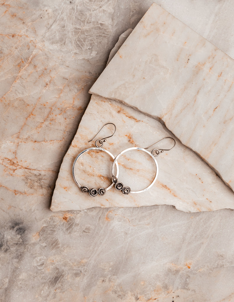 "Artisan Parker Sterling Silver Hoop Earrings with dimensional elements, handcrafted jewelry."

