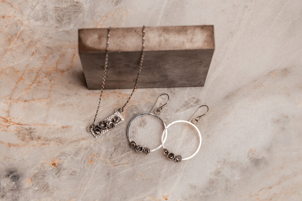 "Handforged Sterling Silver Parker Necklace and hoop Earrings with dimensional texture and artisan details."

