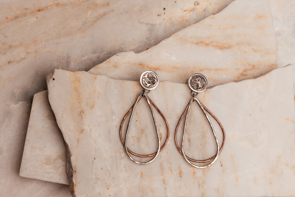 "Signature Roxanna Earrings showcasing artistic blend of sterling silver and copper in teardrop silhouette."

