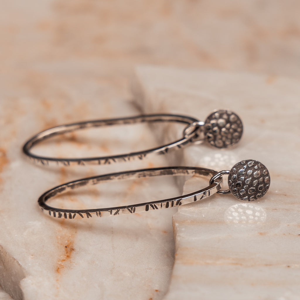 "Bohemian modern sterling silver hoop earrings with artisan texture and organic details"