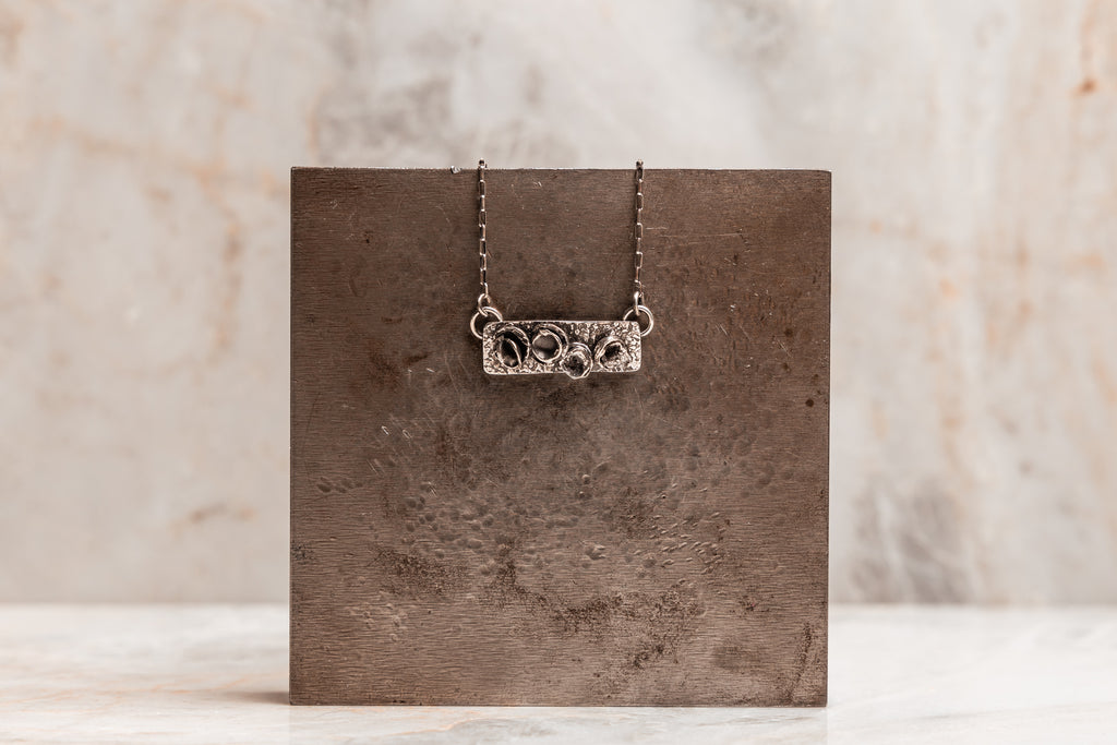 "Contemporary Parker Necklace with dimensional silver design and rustic finish."

